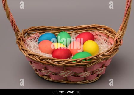 Basket with nine colorful Easter eggs on a gray background. Horizontal photography Stock Photo