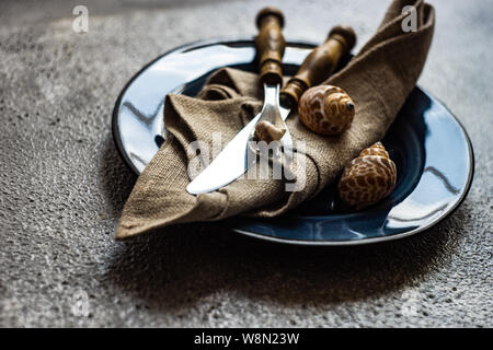 Marine cutlery set with shells and sea stars on grey concrete background with copy space Stock Photo