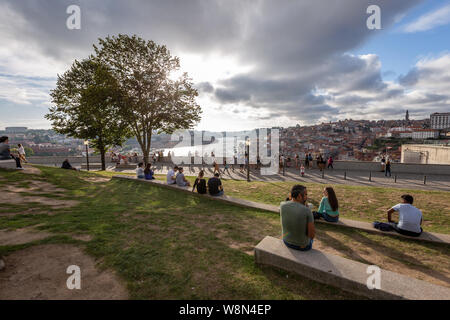 Porto/Portugal - August 05 2019: group of tourist people resting in Jardim do Morro, looking towards Porto in a beautiful scenery Stock Photo