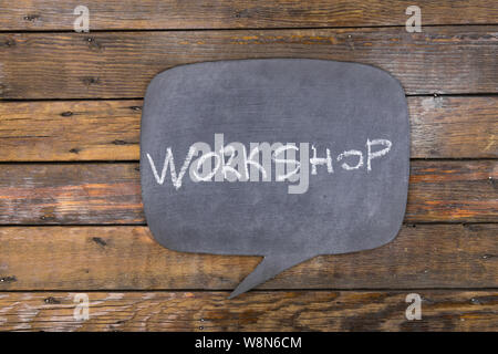 Word, inscription WORKSHOP written in chalk on a blackboard made in the form of thought. Top view. Stock Photo
