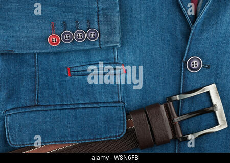 Leather belt lies on a denim jacket. Fashion background. Top view Stock Photo