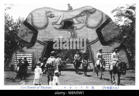 [ 1920s Japan - Japanese Amusement Park ] —   People riding horses cross through the Elephant Tunnel at Kagetsuen Yuenchi amusement park. The park was located in Tsurumi-ku, Yokohama, Kanagawa Prefecture. It was established in 1914 (Taisho 3) by businessman Hirataka Hiraoka (1860-1934). The park was closed in 1946 (Showa 21), the buildings were demolished and a horse race track was built on the park's location.  20th century vintage postcard. Stock Photo