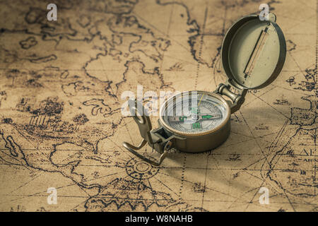 a compass on an old map showing the direction Stock Photo
