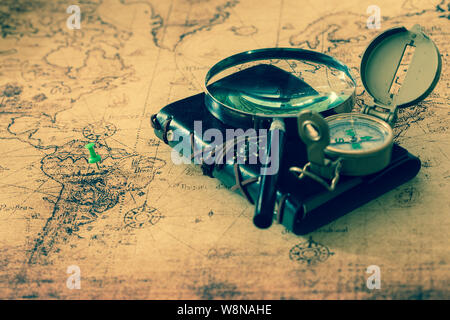 old map with compass, notebook and magnifying glass.  The concept of searching for interesting places or treasures around the world. Stock Photo