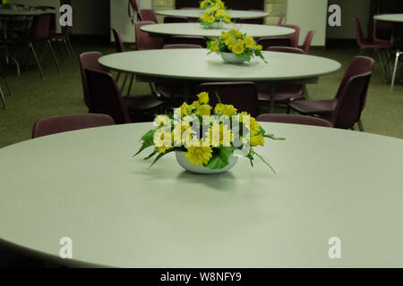 Empty Meeting room with round tables with flower arrangements on table. Stock Photo