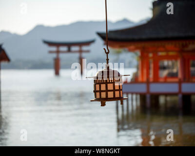 Lantern hanging in temple in front of floating torii shrine Stock Photo