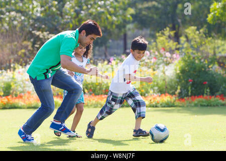 Family playing soccer in a garden Stock Photo