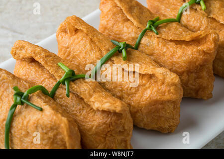 Traditional Japanese fried marinated tofu stuffed with rice, called inari age, close up Stock Photo