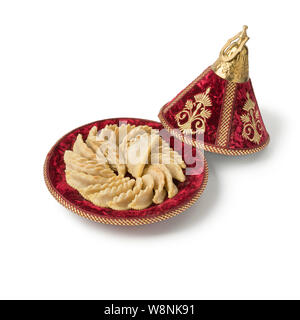 Traditional Gazelle Horns cookies in a festive tagine isolated on white background Stock Photo