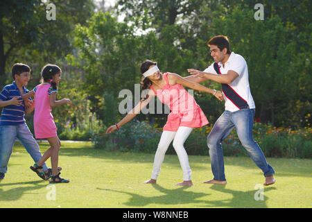 Family playing blind man bluff in a garden Stock Photo