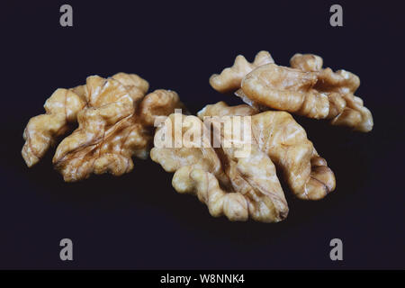 Walnuts on black background. Pile of walnuts without shell closeup for your design and print. Nuts collection Stock Photo