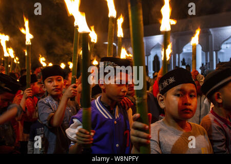 Lhokseumawe, Aceh, Indonesia. 10th Aug, 2019. A group of Acehnese children carry torches as they take part in a parade to mark Eid al-Adha in Lhokseumawe. Muslim people around the world will celebrate Eid al-Adha, or the Feast of the Sacrifice, on Sunday, by slaughtering sheep, goats and cows whose meat will later be distributed to the poor. Credit: Zikri Maulana/ZUMA Wire/Alamy Live News Stock Photo