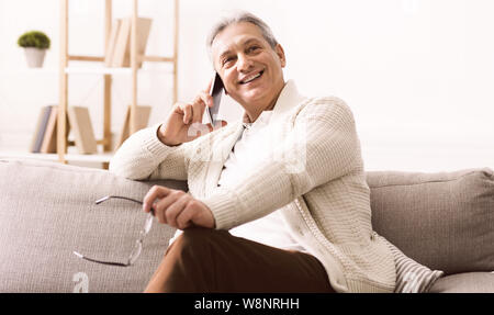 Happy retired man talking on phone, having rest Stock Photo