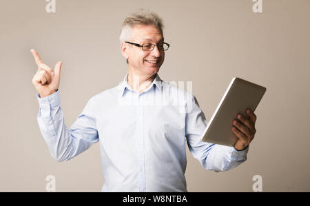 Mature businessman using digital tablet, studio background Stock Photo