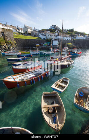 COVERACK, CORNWALL, UK - JUNE 15, 2019.  The harbour and village of Coverack in Cornwall UK during high tide with colourful boats moored on green sea Stock Photo
