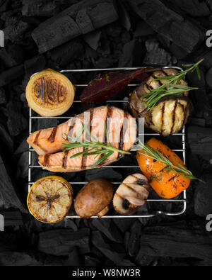 Freshly cooked on grill red fish with vegetables on grid Stock Photo
