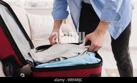 Prepare for business trip. Businessman packing clothes Stock Photo