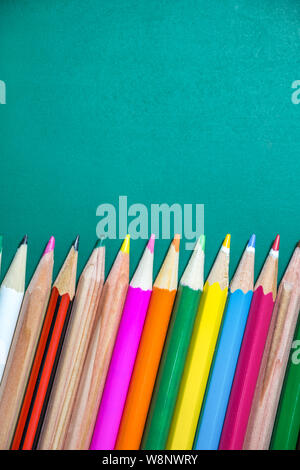 Colorful pencils on chalkboard background. Top view with copy space. Back to school concept. Stock Photo