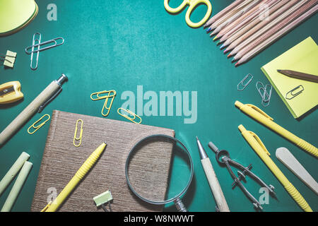 School supplies on chalkboard background, back to school concept. Top view with copy space. Stock Photo
