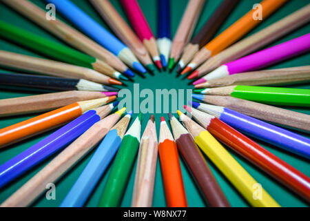 Many different colored pencils on chalkboard background. Back to school concept. Close-up with selective focus. Stock Photo
