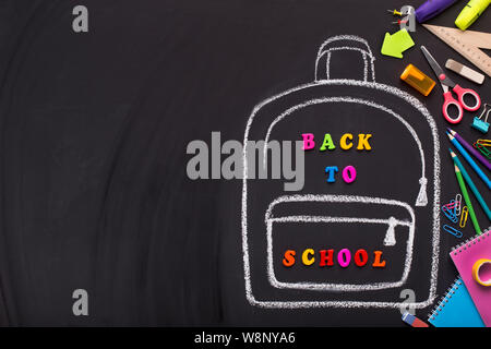 Chalk painted backpack with colored text on black background Stock Photo