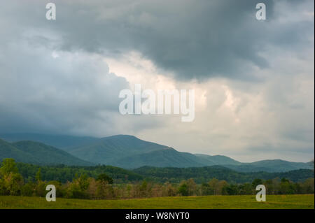 Mist rises from the mountains and storms gather in the sky at Cades Cove in Great Smoky Mountains National Park, Townsend, TN Stock Photo