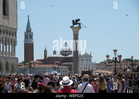 17 June 2019, Italy, Venedig: Tourists on St. Mark's Square (Piazza San Marco). One of the two columns at the Piazzetta is dedicated to Venice's city saint Mark and therefore bears the lion of Mark. Photo: Soeren Stache/dpa-Zentralbild/ZB Stock Photo