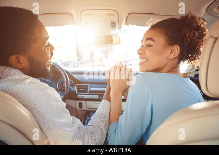 Happy couple holding hands, traveling in car Stock Photo