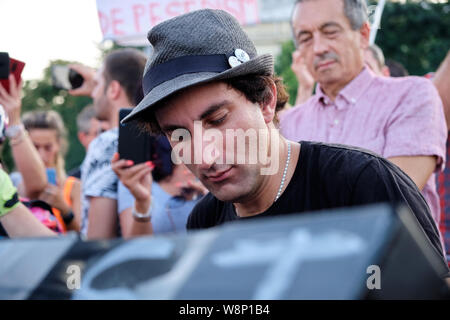 Bucharest, Romania. 10th August 2019. German Pianist Davide Martello plays piano for the crowd of protesters at the Anti corruption manifestation. Martello cancelled other concerts to specifically attend the event which takes place on the anniversary of last year’s violent confrontation in the city. Stock Photo