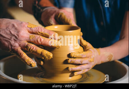 Pottery workshop. Grandpa teaches granddaughter pottery. Clay modeling Stock Photo