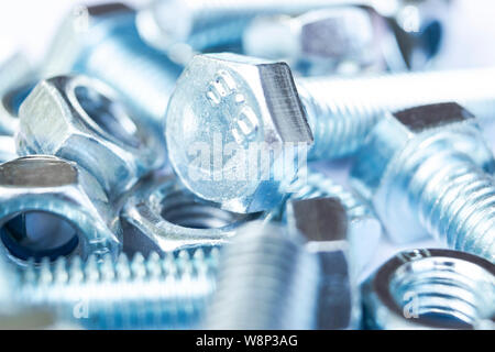 Metal bolts and nuts  in a row background. Chromed screw bolts and nuts isolated. Steel bolts and nuts pattern. Set of Nuts and bolts. Tools for work. Stock Photo