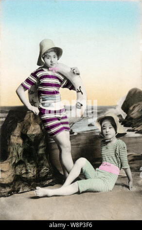 [ 1910s Japan - Japanese Women in Bathing Suit ] —   A studio photo of three young Japanese women wearing modern hats posing in bathing suits. Models for these kind of photos were almost always geisha.  20th century vintage postcard. Stock Photo