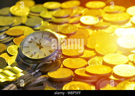 clock and stacks of coins : time - money Stock Photo