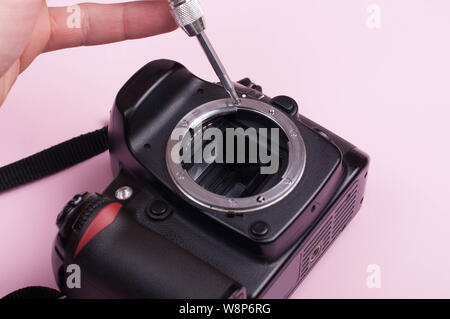Repairing dslr. close up shot with pink bacground Stock Photo