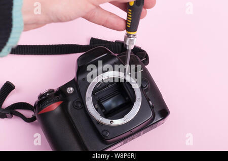 Repairing dslr. close up shot with pink bacground Stock Photo