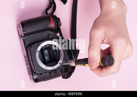 Repairing dslr. close up shot with pink bacground Stock Photo