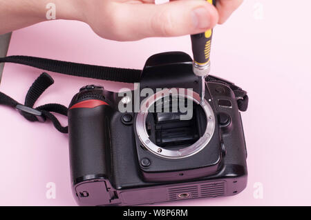 Repairing dslr. close up shot with pink bacground Stock Photo