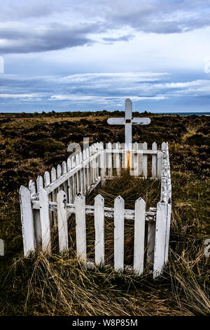 View of picket fence and cross at grave of Frenchman Alexander Dugas who committed suicide in 1929, Sea Lion Island, in the Falkland Islands Stock Photo