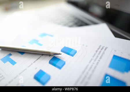 A silver pen lies on documents with Stock Photo