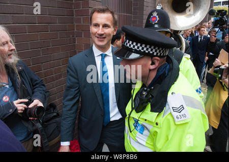 Manchester, UK. 7th October 2015. The Secretary of Health Jeremy Hunt had to be escorted by police as angry anti-austerity and anti-fracking protester Stock Photo