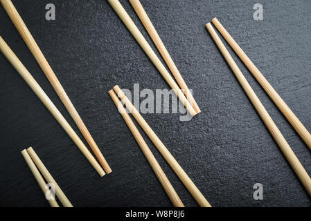 Many bamboo chopsticks on black slate background, top view Stock Photo