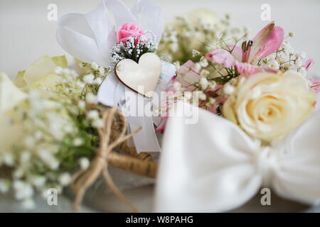 Straw basket with yellow rose, wedding accessories and other gifts on the table. Wedding concept Stock Photo