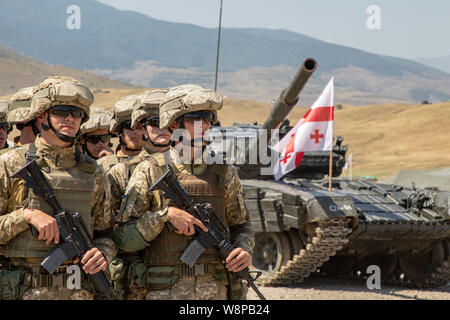 Multinational soldiers stand in formation during the closing ceremony of Agile Spirit 19 at Orpholo Training Area, Georgia, Aug. 9, 2019. AgS19 is a joint, multinational exercise co-led by the Georgian Defense Forces and U.S. Army Europe. Approximately 3,300 military personnel from 14 ally and partner nations participated in this theater security cooperation exercise. The brigade-level exercise incorporated a command-post exercise, field-training exercise and live fires. AgS19 occurred at three training locations in Georgia - Senaki Air Base, Vaziani and Orpholo Training Areas. (U.S. Army phot Stock Photo