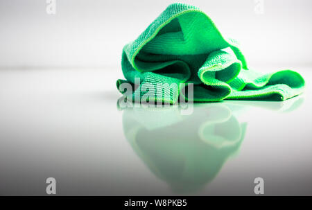 Green kitchen towel isolated on glass surface Stock Photo