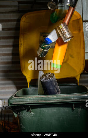 Filling the household Recycling Bin with plastic containers and empty tin cans Stock Photo