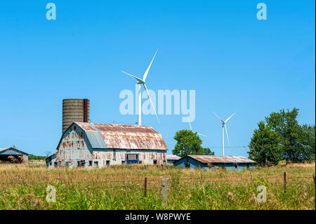 Wind turbines behind barn and silo Stock Photo