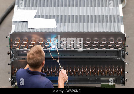 Heinsdorfergrund, Germany. 07th Aug, 2019. An employee of Thermofin GmbH brazes on a heat exchanger during assembly. Thermofin is an internationally active company in the production of components for refrigeration and air conditioning. Credit: Robert Michael/dpa-Zentralbild/ZB/dpa/Alamy Live News Stock Photo