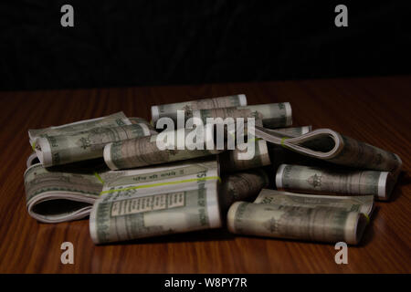Concept of black money showing Pile of Indian currency on table in dark room. Stock Photo