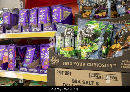 Red Rock Deli lime and black pepper flavour crisps and Cadburys dairy milk chocolate for sale in an Australian supermarket Stock Photo