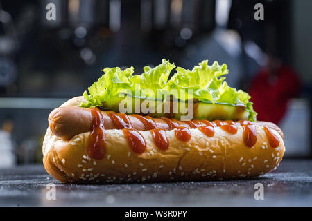 Hot dog with ketchup and mustard on black close-up. Stock Photo
